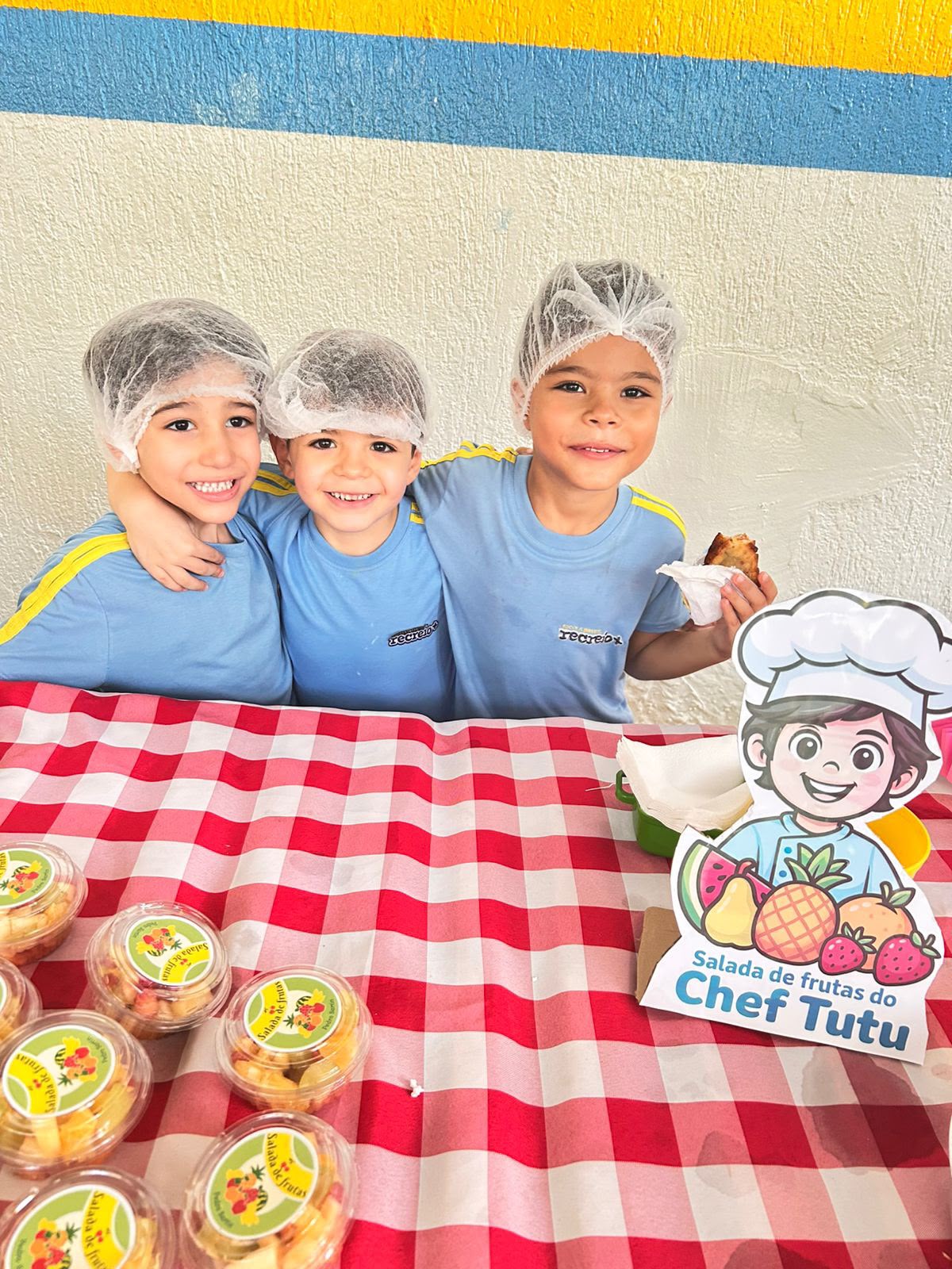 Crianças apresentando saladas de frutas na feira