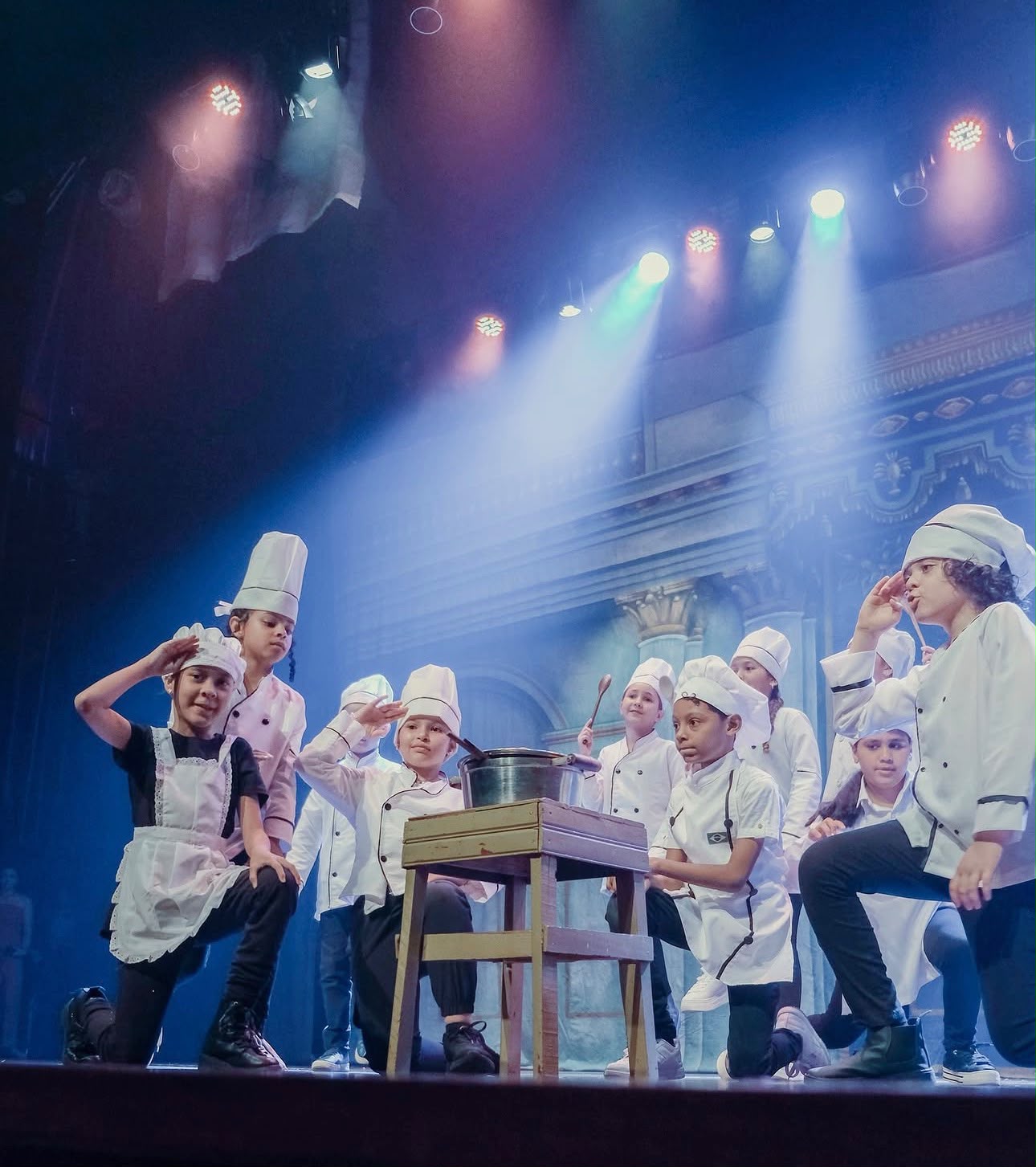 Alunos caracterizados como cozinheiros durante o musical
