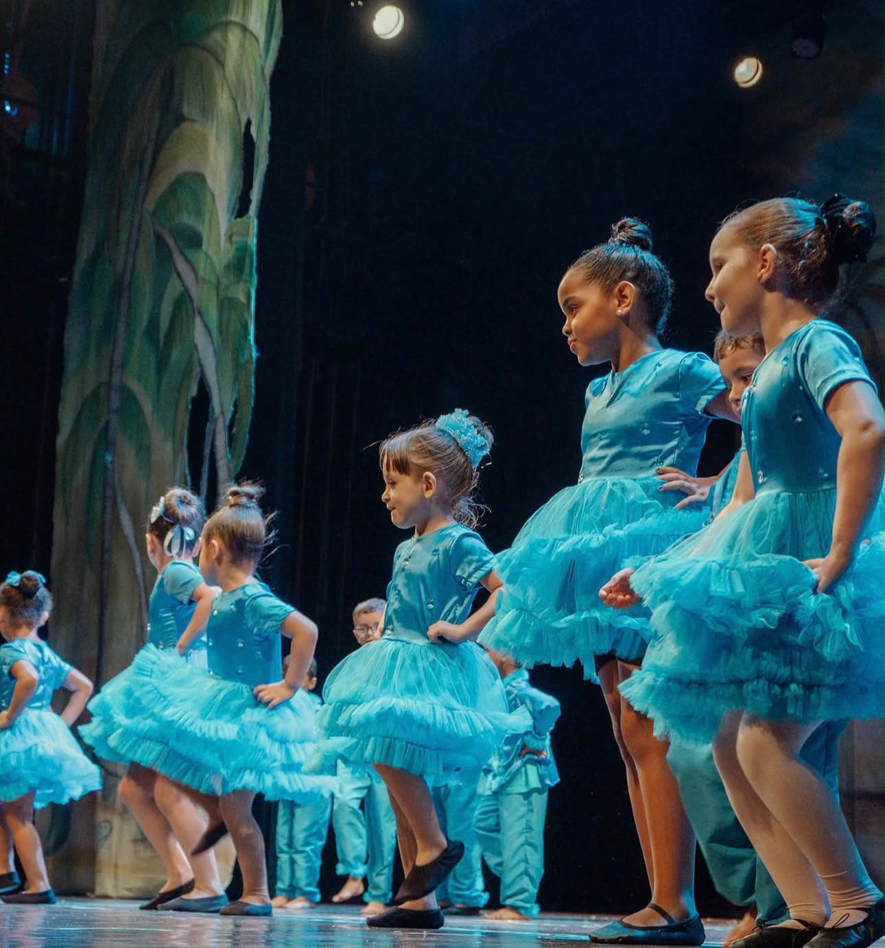 Crianças dançando com figurinos azuis no musical de final de ano